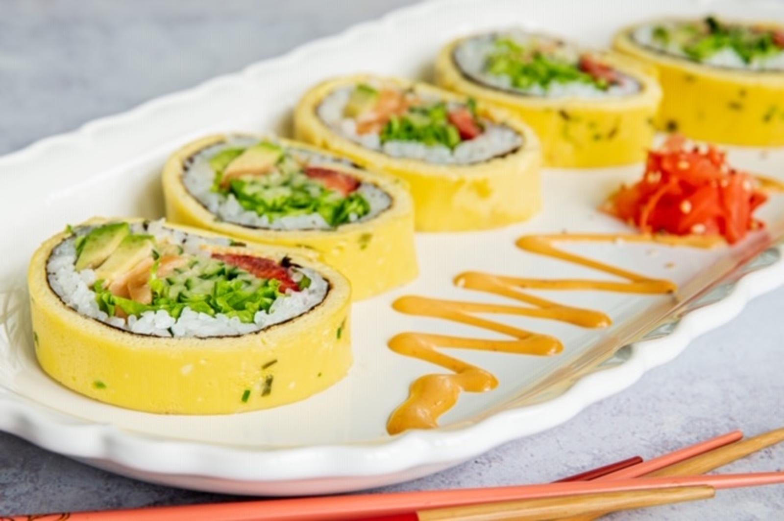 Sushi roll with eggs, salmon, avocado and strawberries